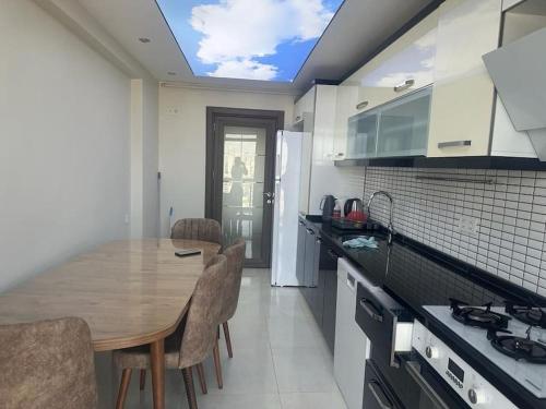 a kitchen with a wooden table and chairs at Apartment with nice view in Beylikduzu