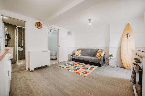 a living room with a couch and a surfboard at Aloha Surf House in Ericeira