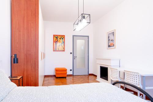 Student's Home في تورينو: غرفة نوم بيضاء مع سرير ومدفأة
