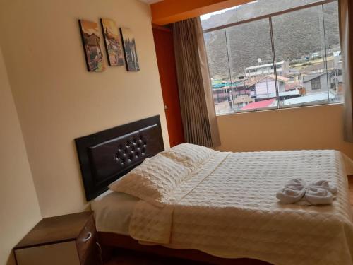 a bedroom with a bed with two pairs of shoes on it at ANDINOS COLCA in Chivay