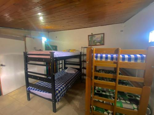 Habitación con 3 literas en una habitación en Tahamies Hostal - Artesanos y Turistas., en Guatapé