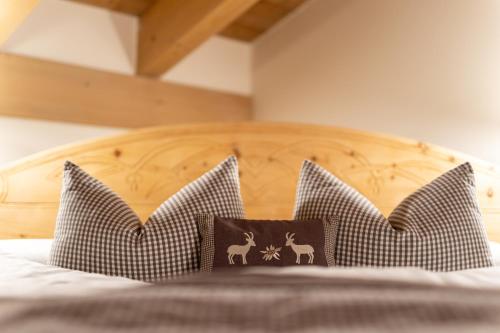 a bed with a wooden headboard and pillows on it at Camana Veglia in Livigno