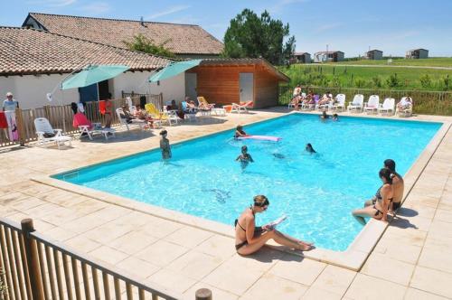 a group of people sitting in a swimming pool at Le heron cendre in Orist