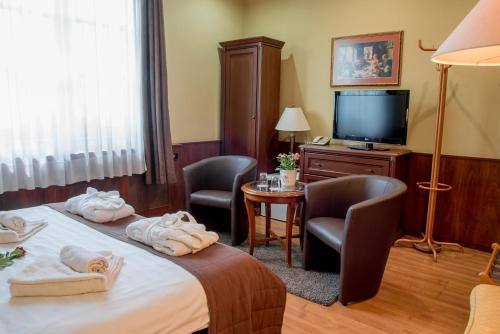 Una televisión o centro de entretenimiento en Nyerges Hotel Termál Superior