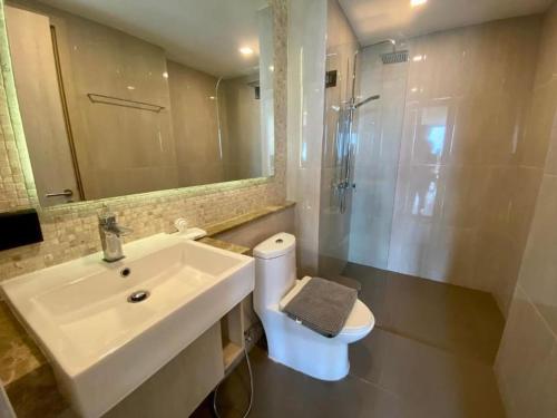 Un baño con lavabo, inodoro y ducha. en Toppmodern lägenhet i Bang Saray, en Bang Sare