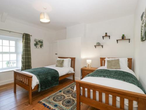 Ce lit se trouve dans un dortoir doté de murs blancs et de parquet. dans l'établissement Builth House, à Abergavenny