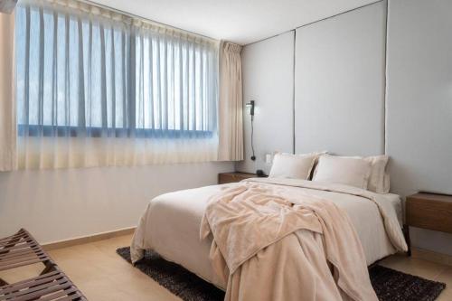 a bedroom with a large bed and a window at Nuevo Departamento en Zibatá Querétaro, 4 Personas in La Cañada