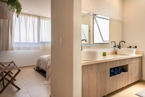 a bathroom with two sinks and a bed and a mirror at Nuevo Departamento en Zibatá Querétaro, 4 Personas in La Cañada