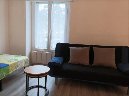 - un salon avec un canapé et une table dans l'établissement ROSE, à Saint-Mandé