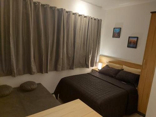 a bedroom with a bed and a window with curtains at Flat / Studio Allianz Parque in Sao Paulo