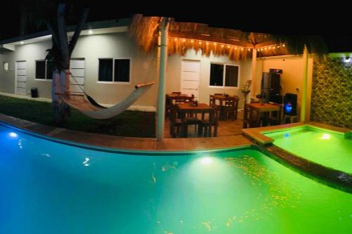 a swimming pool with a hammock in a house at Posada chachalacas in Chachalacas