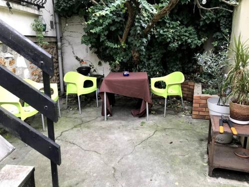 巴尼奧雷的住宿－Pavillon avec cour privée，一张桌子,上面摆放着黄色的椅子,一张桌子,上面摆放着紫色