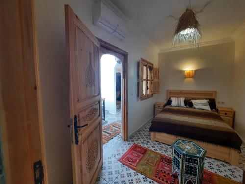 ein Schlafzimmer mit einem Bett und einer offenen Tür in der Unterkunft Riad Rayan in Marrakesch