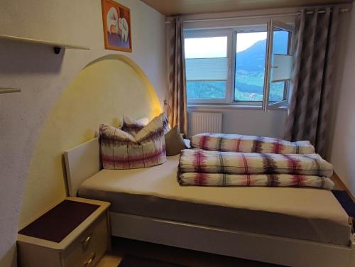 a small bedroom with a bed with a large window at Haus Gertrud in Jerzens