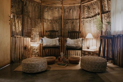 ein Wohnzimmer mit 2 Stühlen und 2 Hockern in der Unterkunft Vila Cerrado in Alto Paraíso de Goiás