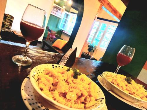 a table with two plates of pasta and two glasses of wine at Donde Pepe Loft Apartasuite. in Zipaquirá