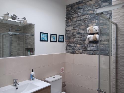 a bathroom with a sink toilet and a stone wall at Casa Gloria in Tías