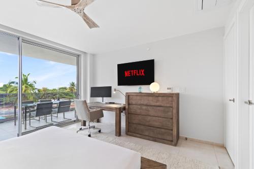 a bedroom with a bed and a desk with a tv at O Condominium Beachfront Residences, by Bocobay Aruba in Palm-Eagle Beach