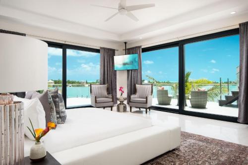 a living room with a white couch and large windows at Horizon Villa in Taylor Bay Beach