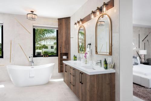 a bathroom with a white tub and a sink and a mirror at Horizon Villa in Taylor Bay Beach