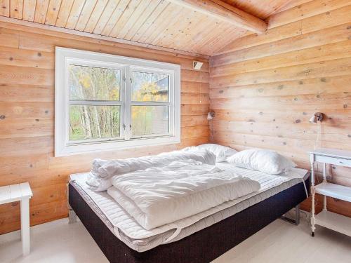 uma cama num quarto de madeira com uma janela em Holiday home Læsø II em Læsø