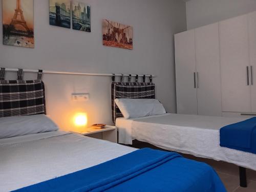 a bedroom with two beds and a lamp on a table at Casa Gloria in Tías