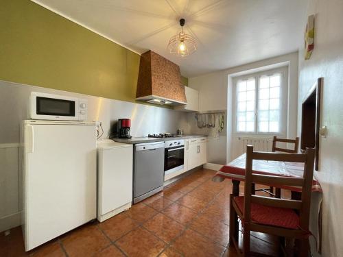 a kitchen with a white refrigerator and a table at Barrukia in Uhart-Cize