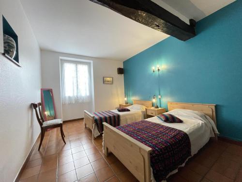 a bedroom with two beds and a blue wall at Barrukia in Uhart-Cize