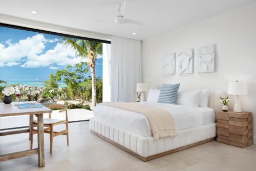 1 dormitorio con cama, mesa y vistas en Beachwood Villa en Turtle Cove