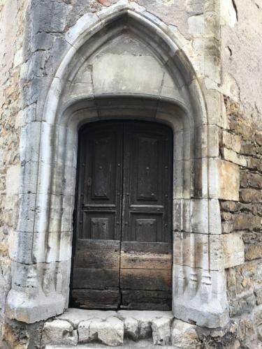 a large wooden door in a stone building at Joli Cocon pour 3 personnes vue sur les toits du centre de Caylus in Caylus