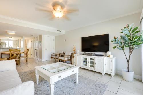 a living room with a tv and a couch and a table at St Augustine Poolside Oasis with Private Patio! in St. Augustine
