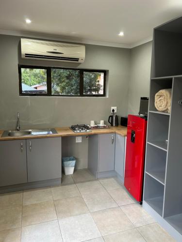 a kitchen with a counter and a red refrigerator at Hillsview, Roodepoort in Roodepoort