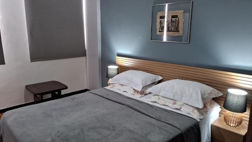 a bedroom with a large bed with two pillows at Aconchegante apartamento Teresópolis in Teresópolis