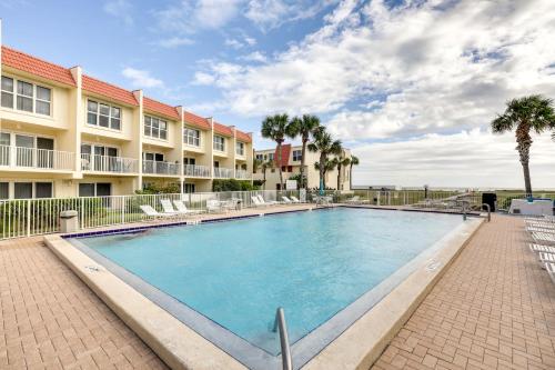 a swimming pool at a resort with chairs and a building at St Augustine Poolside Oasis with Private Patio! in St. Augustine