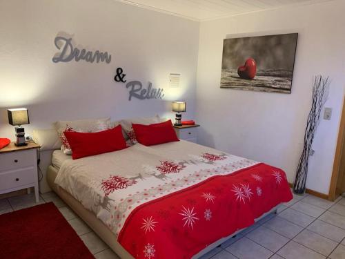 1 dormitorio con 1 cama con almohadas rojas en Hanne's Gästestudio, en Osann-Monzel