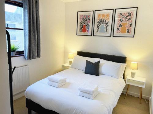 1 dormitorio con 1 cama blanca grande y 2 almohadas en 3 bed home in Cheltenham Town Centre with FREE PARKING for 1 car en Cheltenham