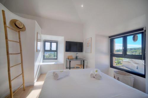 une chambre avec un lit, une télévision et des fenêtres dans l'établissement IMMOGROOM - Superbe villa - Piscine - Vue mer - Parking - Clim, à Vallauris