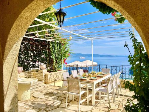 a patio with a table and chairs and the ocean at Villa Tesoro Kalami with private pool by DadoVillas in Kalami