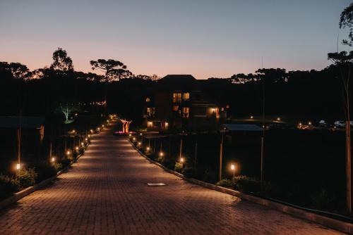 a brick road with street lights at night at WoodStone Hotel Fazenda in Gramado