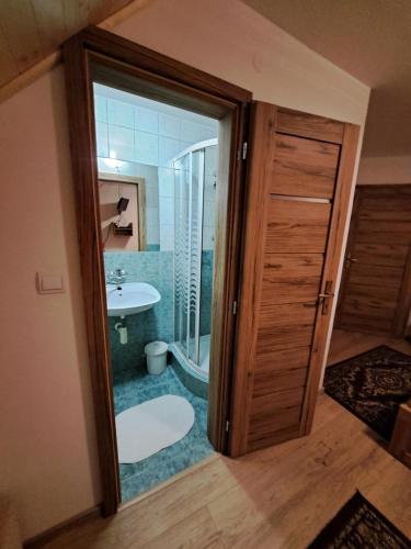 een badkamer met een douche, een toilet en een wastafel bij Chata Berešík in Terchová