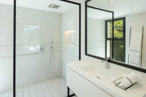 a white bathroom with a sink and a shower at Villa Mercedes - Luxury 5-Bedroom Villa in Las Brisas, Marbella in Marbella