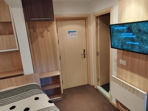 a room with a flat screen tv and a door at Apartment Dunja Konaci in Kopaonik