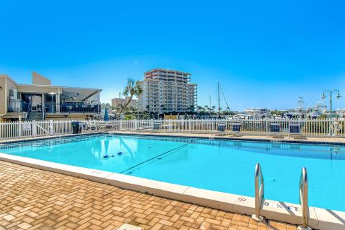 ein großer blauer Pool mit einem Gebäude im Hintergrund in der Unterkunft ​Sandpiper cove in Destin