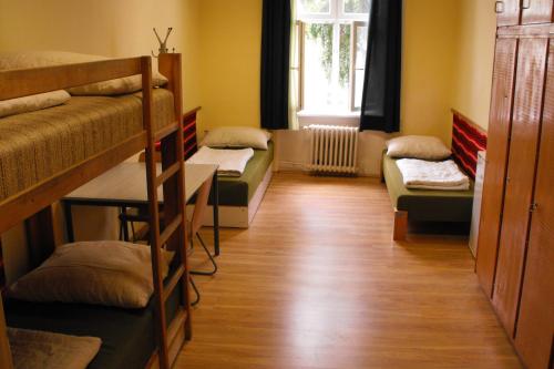 a room with three bunk beds and a couch at Mogyorodi Hostel in Budapest