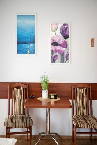 a table with two chairs and a table with flowers at Hostel Wielka Krokiew in Zakopane