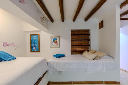 two beds in a room with white walls at Casa Caracola in Tubará
