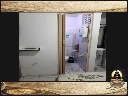 a view of a bathroom with a toilet through a glass door at Pousada Piratas Di San Rocco in Maceió