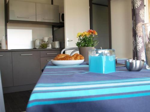 une table avec un chiffon de table bleu et une assiette de pain dans l'établissement Le brochet, à Orist