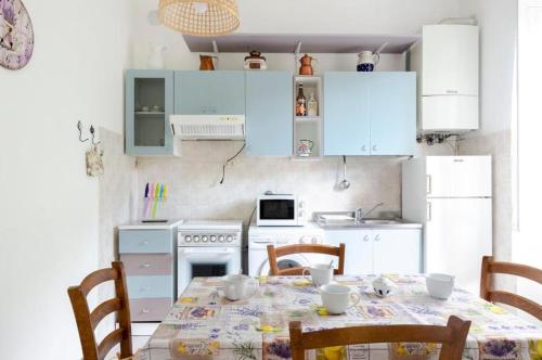 a kitchen with a table and chairs and a kitchen with blue cabinets at 2 appartamenti totale 12 posti letto in Borgonovo