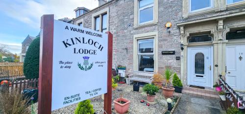 un cartel frente a una casa con jardín en mySTAYINN Kinloch Lodge en Inverness